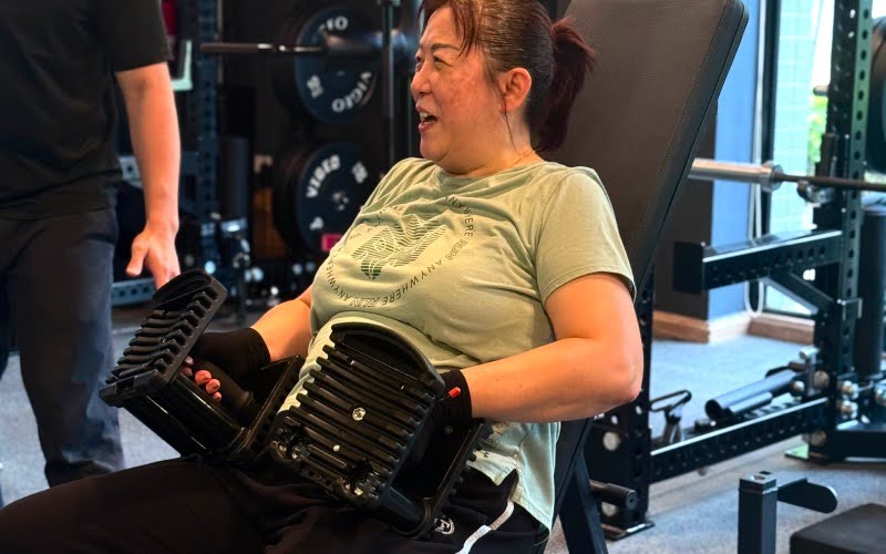 Woman performing dumbbell bench press for blood glucose management