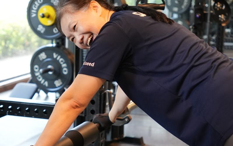 Senior woman smiling while performing push-ups during strength training